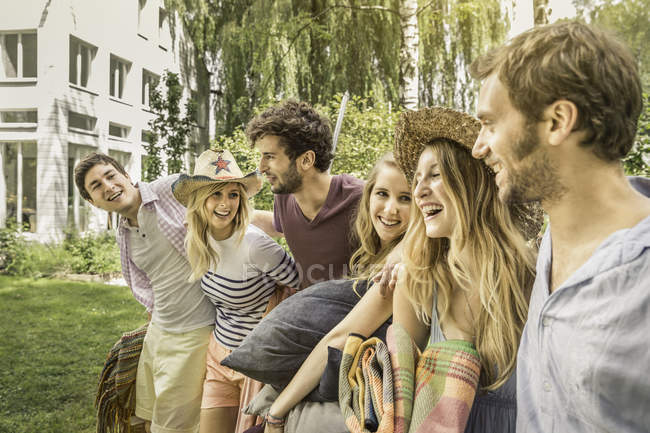 Male and female friends preparing for picnic in garden — Stock Photo