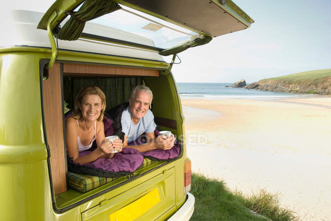 Mature couple lying in camper van — Stock Photo