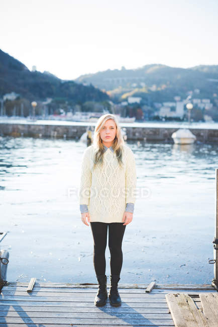 Portrait of young woman standing on lakeside pier, Lake Como, Italy — Stock Photo