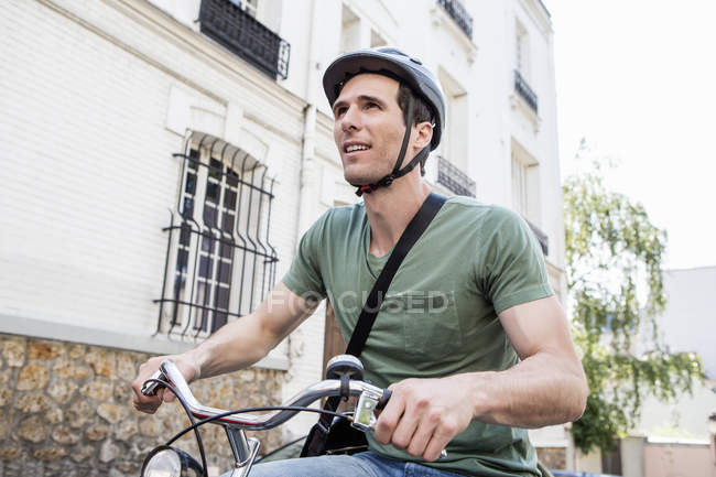 Hombre adulto en bicicleta en la calle de la ciudad - foto de stock