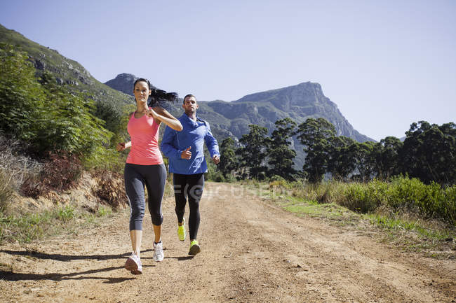 Jeune couple jogging en forêt — Photo de stock