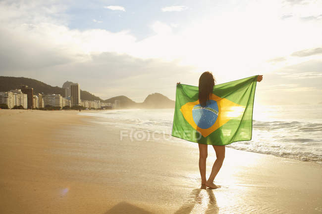 Mulher segurando bandeira brasileira na Praia de Copacabana, Rio, Brasil — Fotografia de Stock