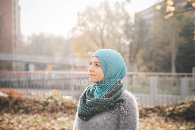 Retrato de una mujer joven con hijab mirando en el parque - foto de stock