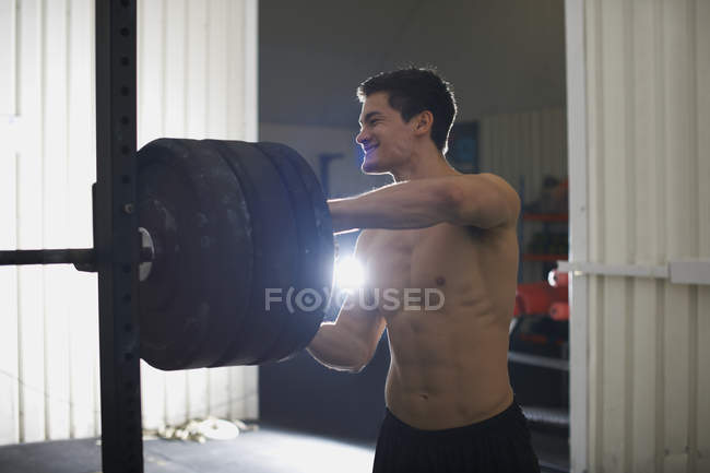 Jeune homme s'entraînant avec des cloches dans la salle de gym — Photo de stock