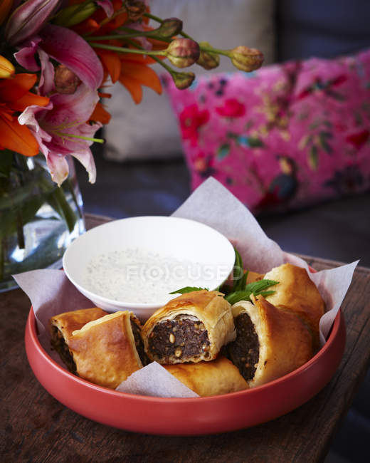 Bowl of sausage rolls on table — Stock Photo