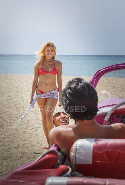 Coppia con il loro convertibile in spiaggia — Foto stock