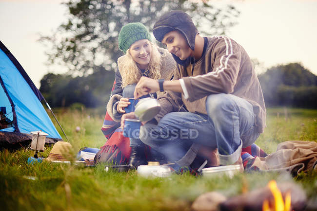 Young camping couple pouring tea — Stock Photo
