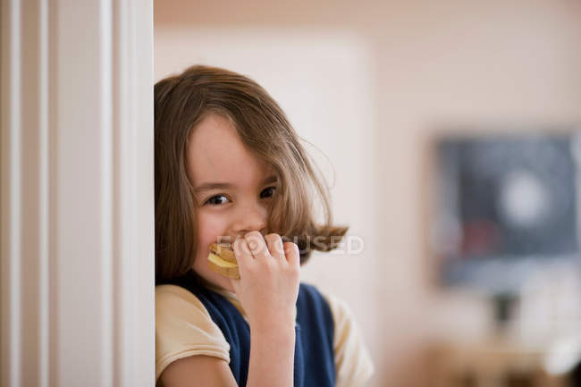 Mädchen isst Sandwich und schaut in die Kamera — Stockfoto