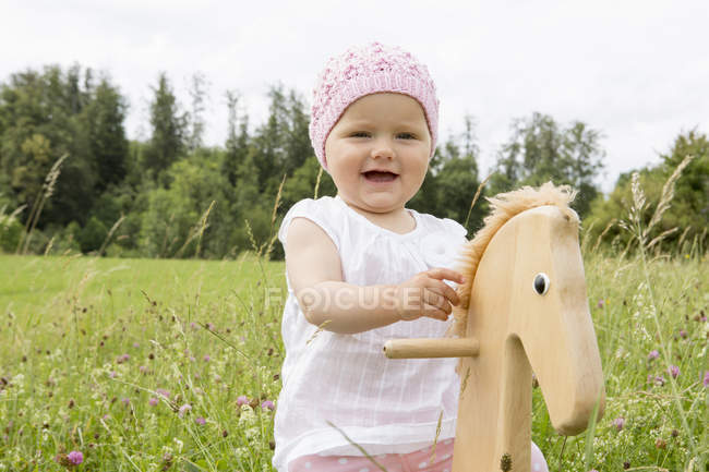 Bébé fille jouer sur le cheval passe-temps — Photo de stock