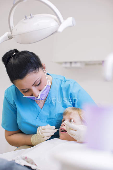 Ragazza sulla sedia del dentista con esame dentale — Foto stock