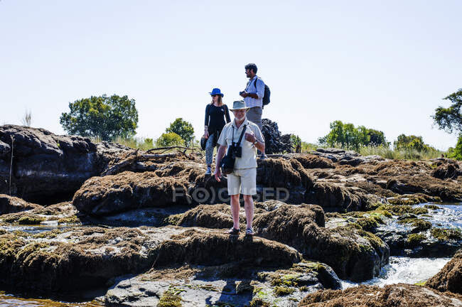 Paar und erwachsener Mann auf Felsen in der Nähe der Victoria Falls, Sambia — Stockfoto