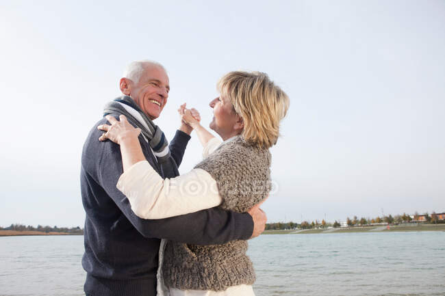 Старшая пара танцует на озере — стоковое фото