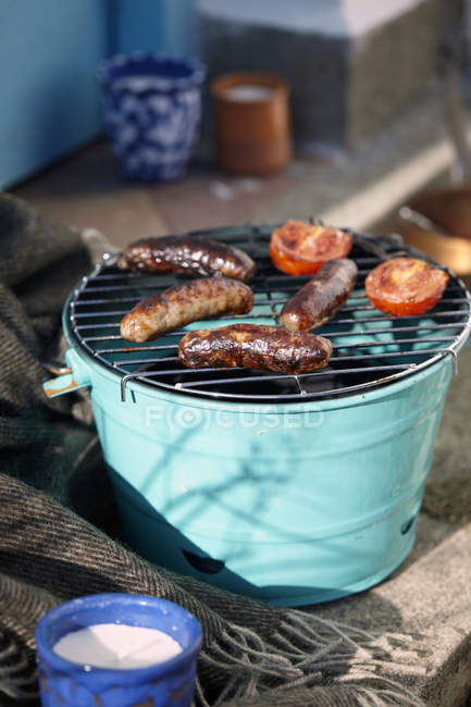 Barbecue with sausages and tomatoes — Stock Photo