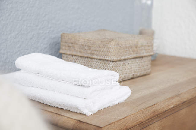 Close up di pila di asciugamani e box sul comò — Foto stock