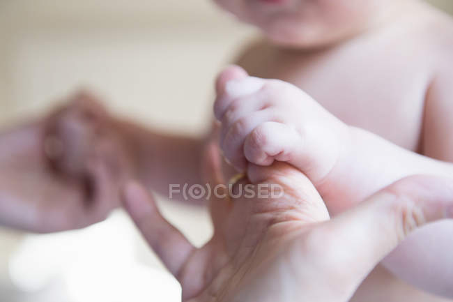 Baby boy holding mother's hands, focus on hands — Stock Photo