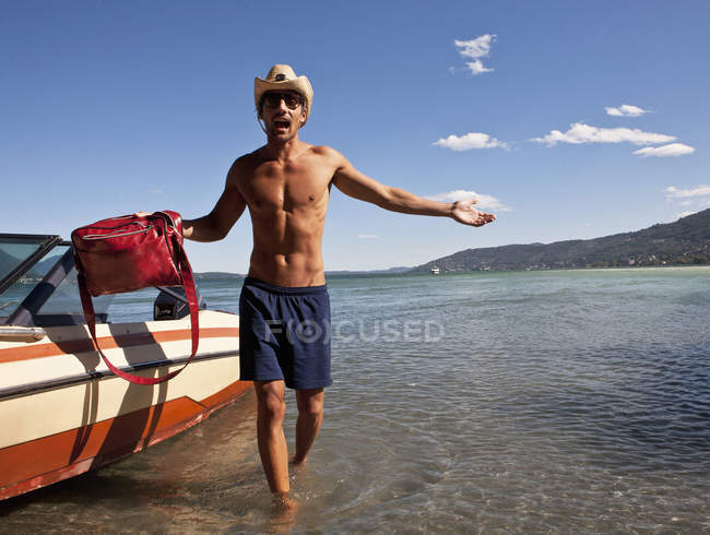 Молодой человек везет сумку с энергетической лодки, Вербания, Италия — стоковое фото