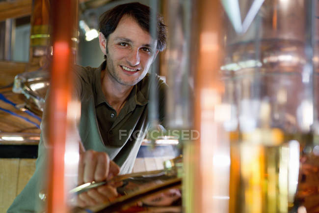 Male brewer working in beer brewhouse — Stock Photo
