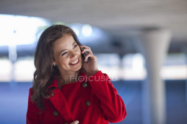 Young woman chatting on smartphone in city underpass — Stock Photo