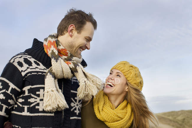 Couple souriant mi-adulte sur la côte en hiver — Photo de stock