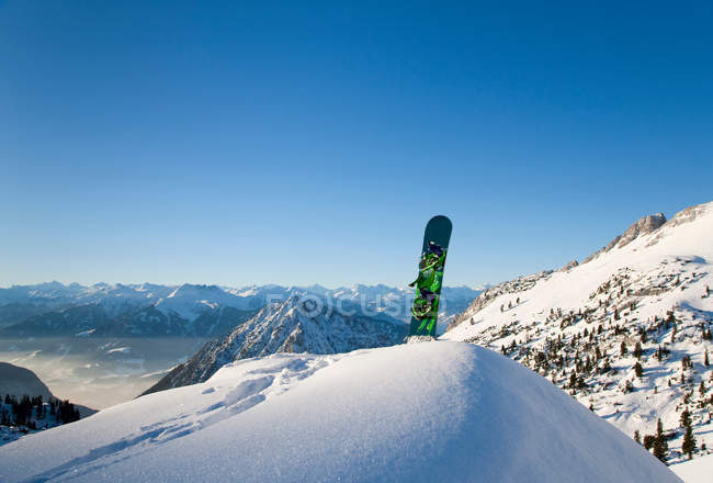 Snowboard in mountain peak — Stock Photo
