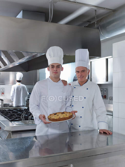 Chefs apprentice with home made cake — Stock Photo
