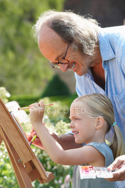 Grandfather and granddaughter painting — Stock Photo