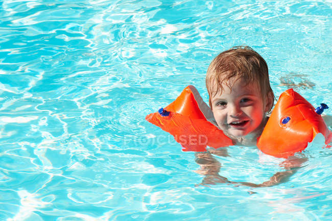 Baby boy swimming with water wings — Stock Photo