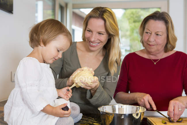 Großmutter, Tochter und Enkelin bereiten Teig in der Küche zu — Stockfoto