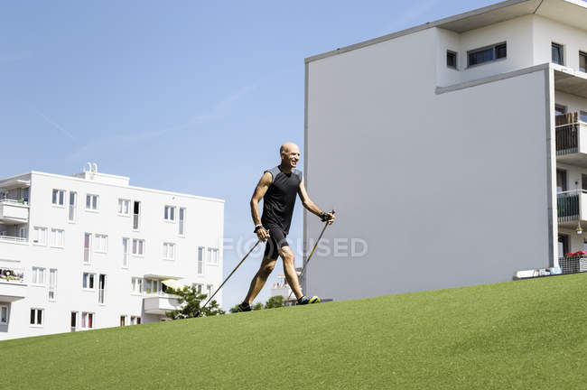Mature male exercising with walking poles in park — Stock Photo