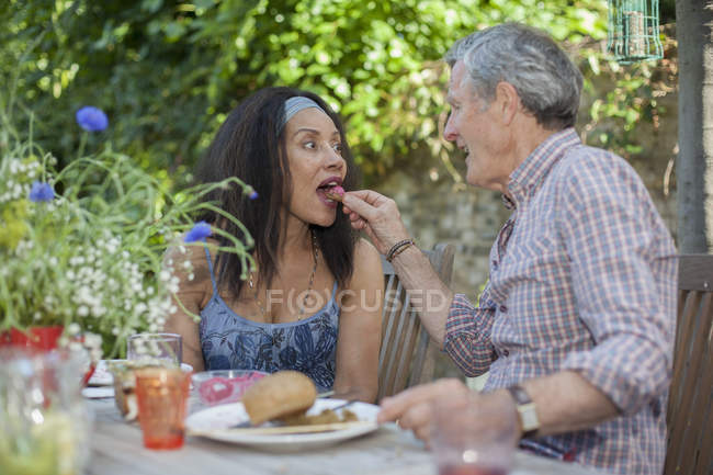 Пара пожилых людей ест на открытом воздухе — стоковое фото