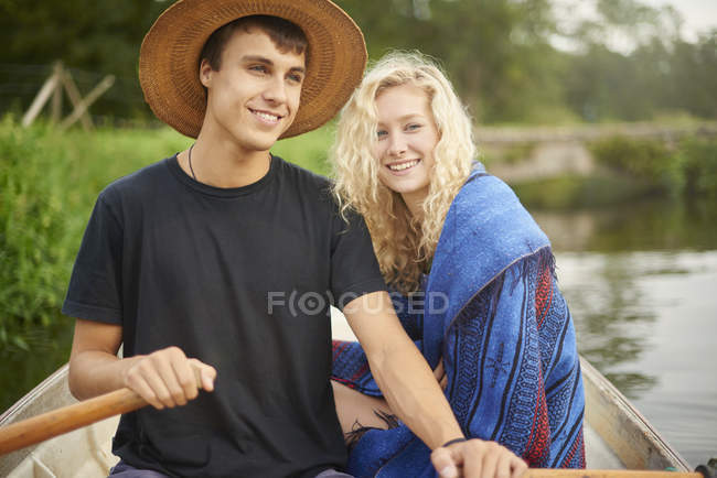 Portrait of young couple in river rowing boat — Stock Photo