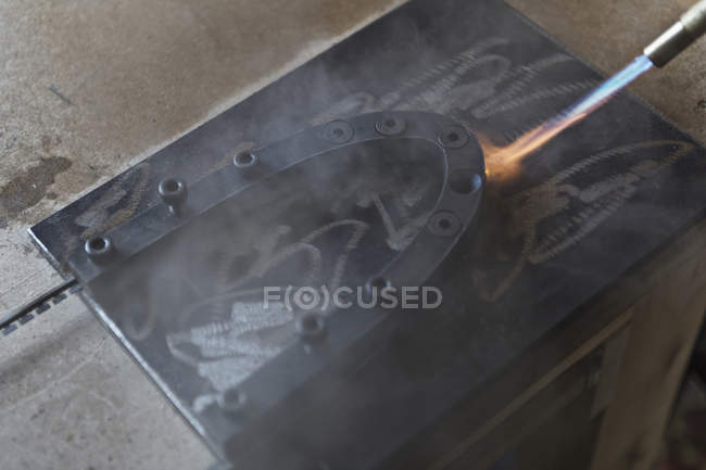 Flamme soufflante sur métal en atelier, gros plan — Photo de stock