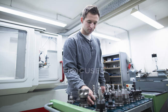 Jeune technicien masculin choisir foret dans l'atelier — Photo de stock