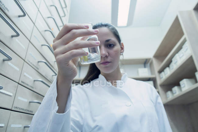 Farmacista in farmacia che tiene in mano il medicinale — Foto stock