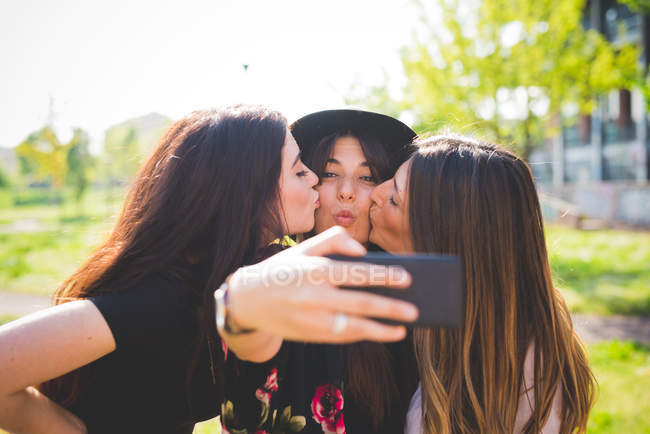 Trois jeunes femmes posant pour selfie dans le parc — Photo de stock