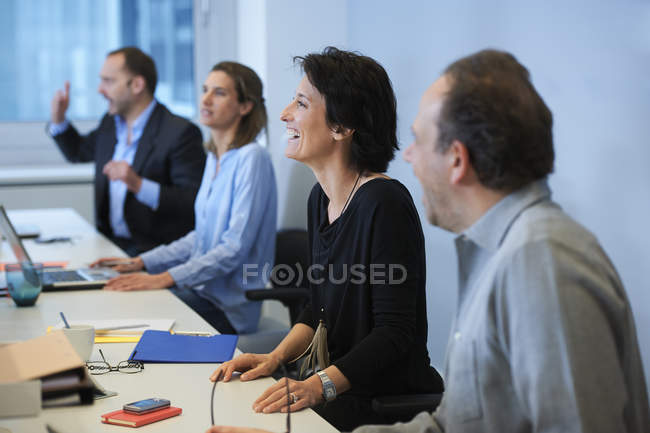 Бизнесмены сидят за столом в офисном интерьере — стоковое фото