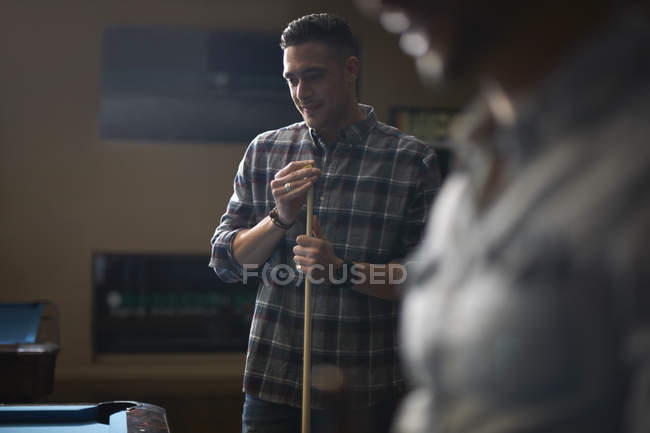 Homem com sinuca em pé na mesa de bilhar — Fotografia de Stock