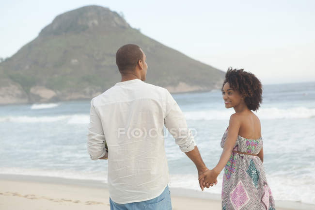 Пара прогулюються рука об руку на пляжі, Ріо-де-Жанейро, Бразилія — стокове фото