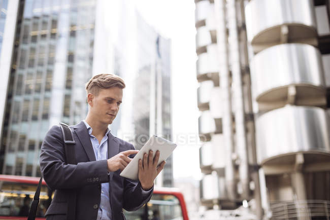 Homme d'affaires utilisant une tablette numérique dans la rue, Londres, Royaume-Uni — Photo de stock
