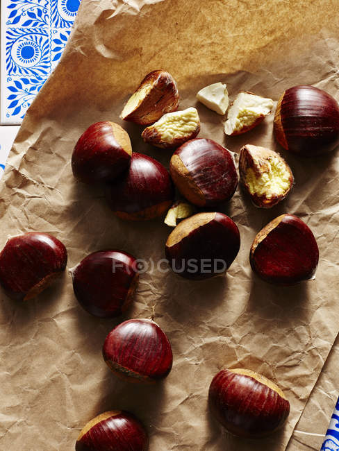 Close up shot of chestnuts on brown paper — Stock Photo