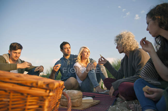 Cinco amigos haciendo picnic en la playa de Bournemouth, Dorset, Reino Unido - foto de stock