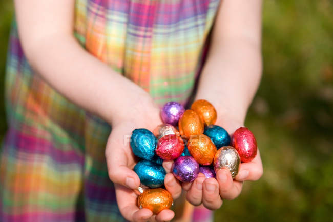 Cropped image of kid holding easter eggs in hands — Stock Photo