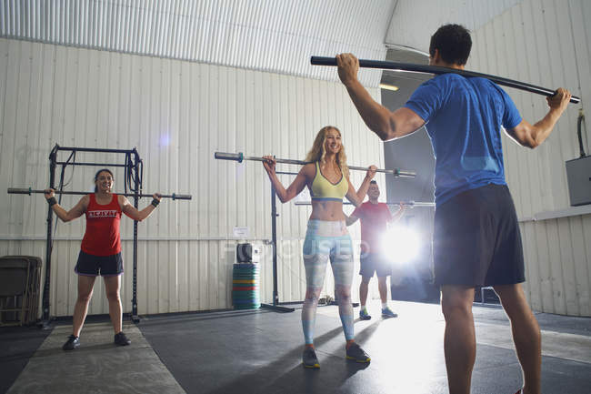 People working out with bars in group crossfit class — Stock Photo