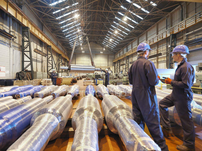 Trabajadores en discusión en gran fábrica de ingeniería - foto de stock