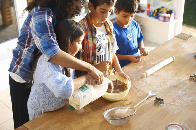 Mutter und Kinder backen zu Hause in der Küche — Stockfoto