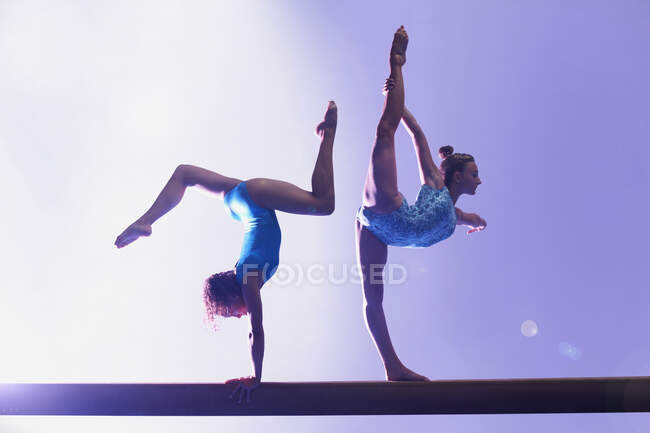 Gymnasts doing routine on bar — Stock Photo