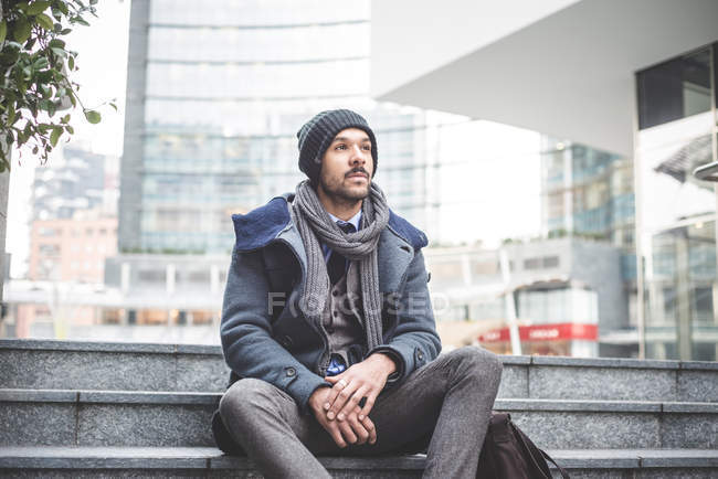 Mid adult businessman sitting on office stairway — Stock Photo