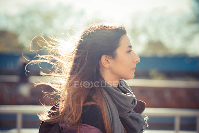 Mujer adulta que camina a lo largo de la carretera ventosa - foto de stock
