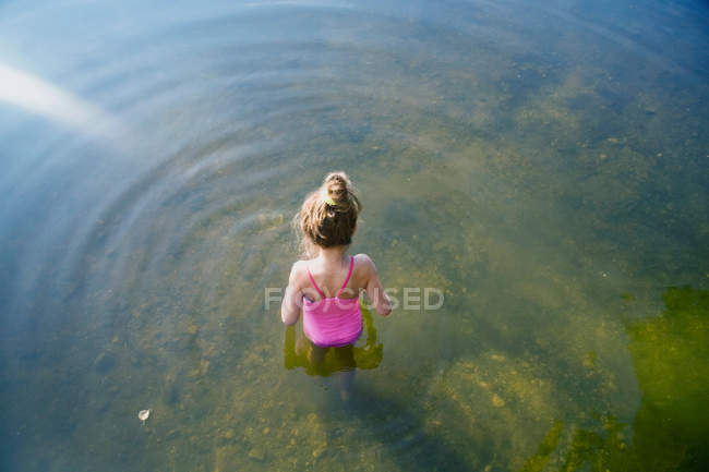 Vista ad alto angolo della ragazza in muta in piedi in acqua — Foto stock