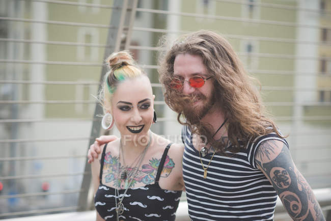 Punk hippy couple strolling and chatting on city street — Stock Photo